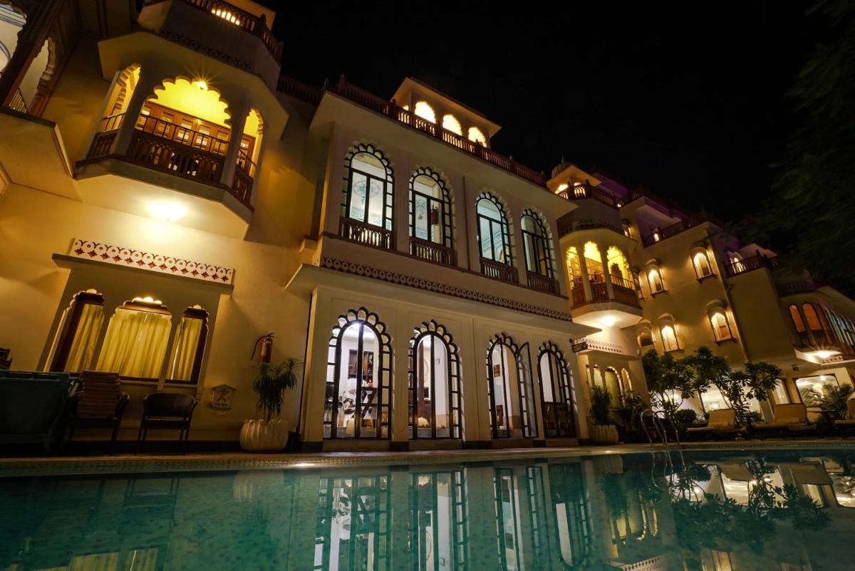 a house with a swimming pool at night at Shahpura House in Jaipur