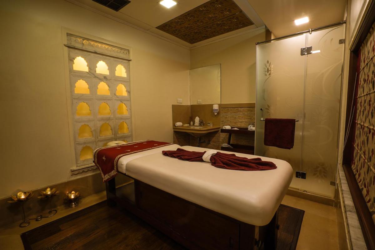 a bathroom with a large bed and a shower at Shahpura House in Jaipur