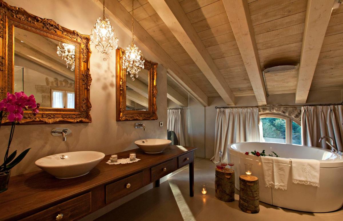 Un baño con dos lavabos y una bañera grande. en La Vella Farga Hotel, en Lladurs