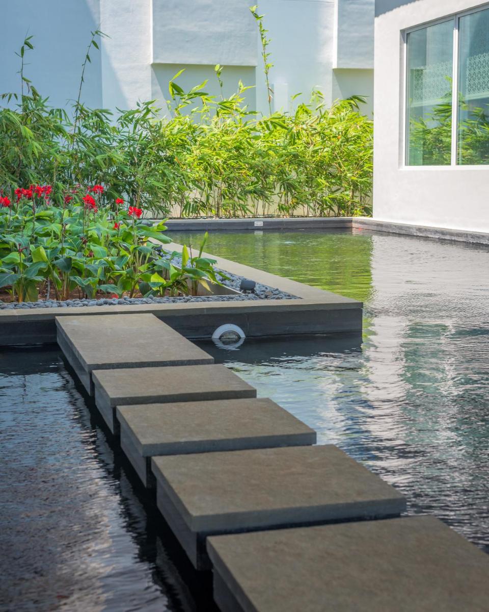 a swimming pool with a path in a building at The Residency Towers, Rameswaram in Rāmeswaram
