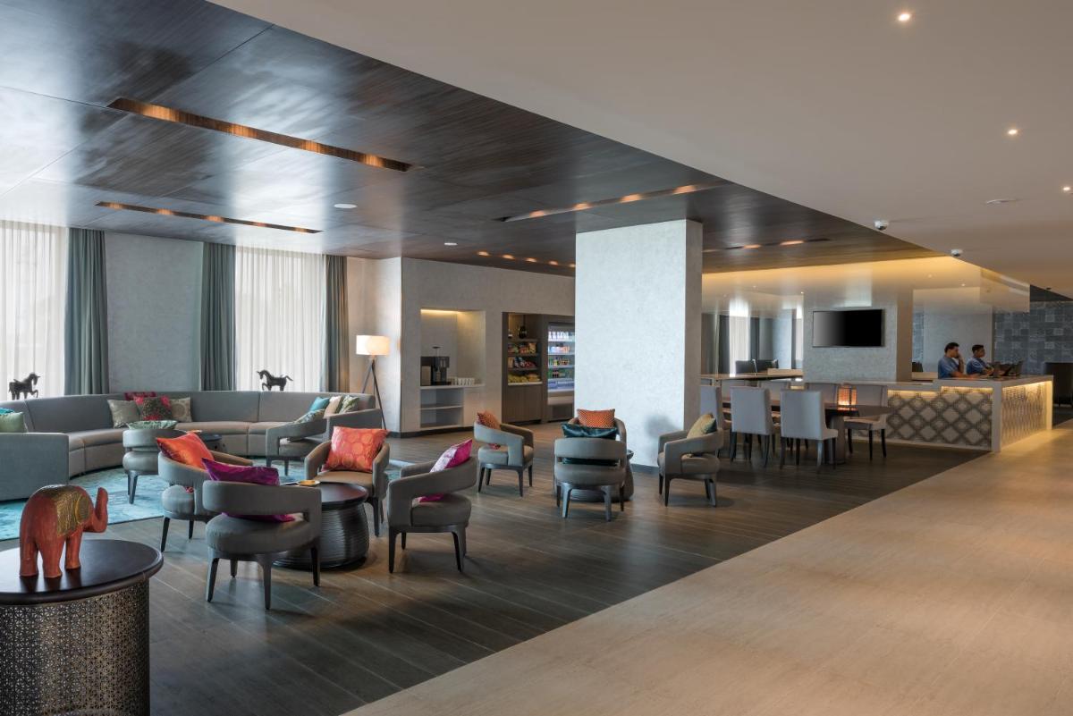a lobby of a hotel with chairs and tables at The Residency Towers, Rameswaram in Rāmeswaram