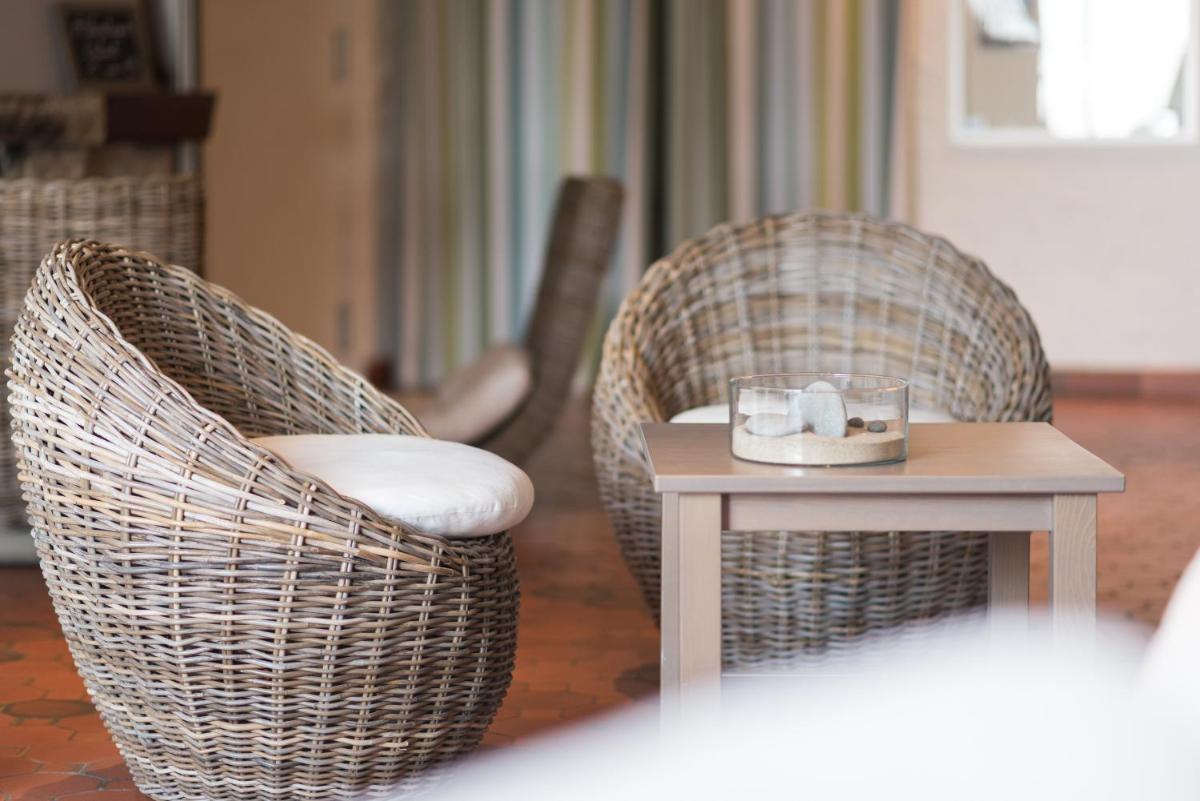 - 2 chaises en osier et une table dans une pièce dans l'établissement Logis Latitude Ouest Hôtel Restaurant & Spa, à Locronan 54 autres photos