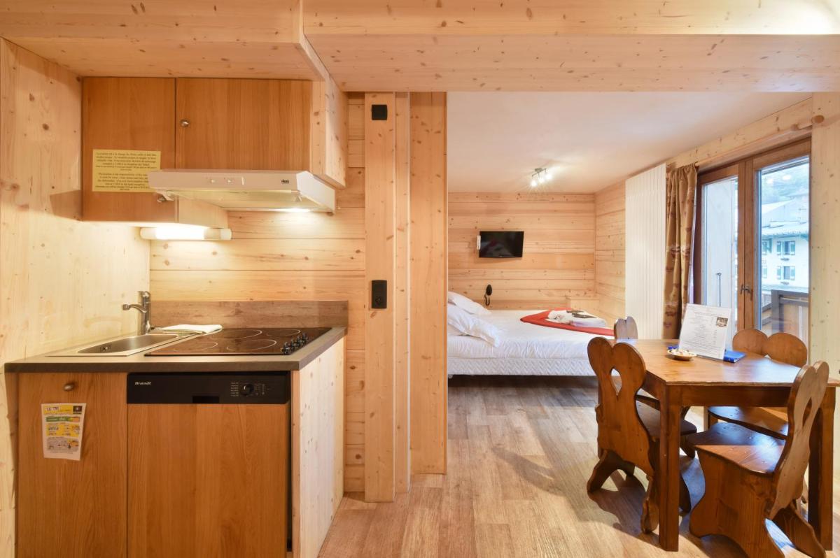 - une cuisine avec un évier et une table dans une chambre dans l'établissement Loc'Hotel Alpen Sports, aux Gets