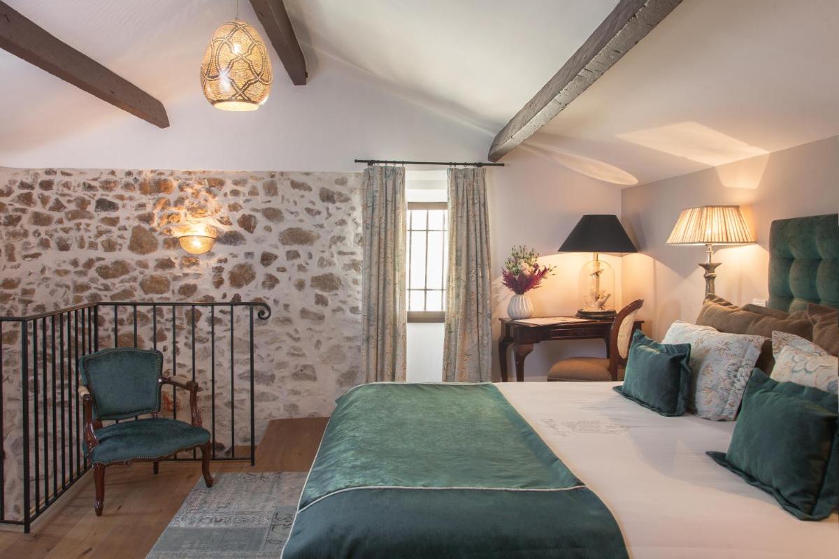 une chambre avec un lit et une chaise dans l'établissement Chateau Eza, à Èze