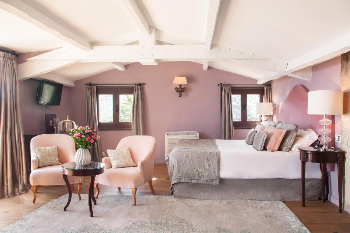 - une chambre avec un grand lit et des murs roses dans l'établissement Chateau Eza, à Èze