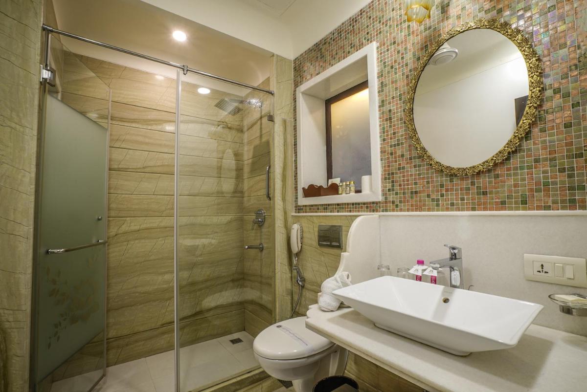 a bathroom with a toilet and a sink and a shower at Shahpura House in Jaipur