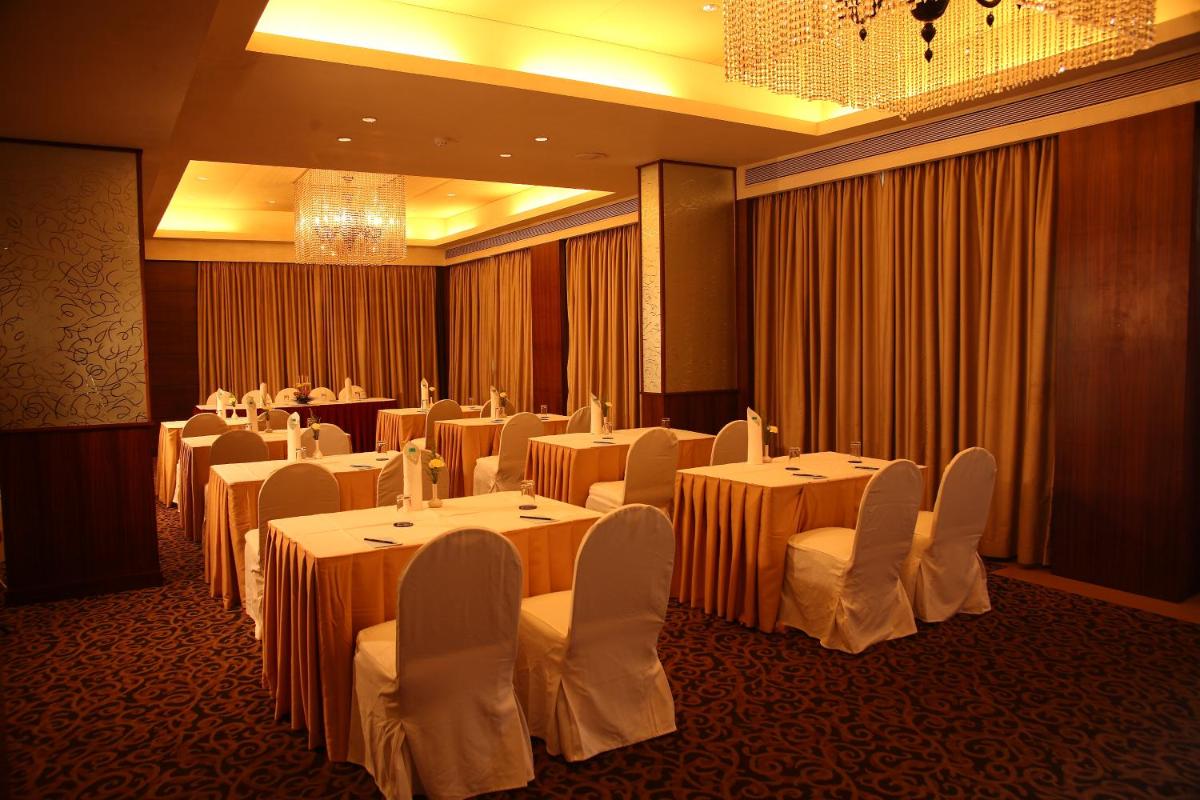 a banquet room with tables and white chairs at Sun-n-Sand Mumbai Juhu Beach in Mumbai