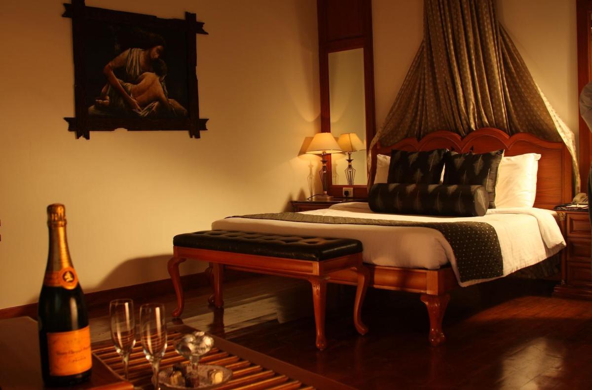 a bedroom with a bed and a bottle of wine at Sun-n-Sand Mumbai Juhu Beach in Mumbai