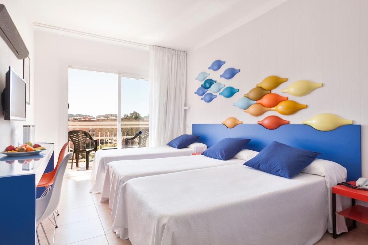 Una habitación de hotel con dos camas y balcón. en Evenia Olympic Resort, en Lloret de Mar