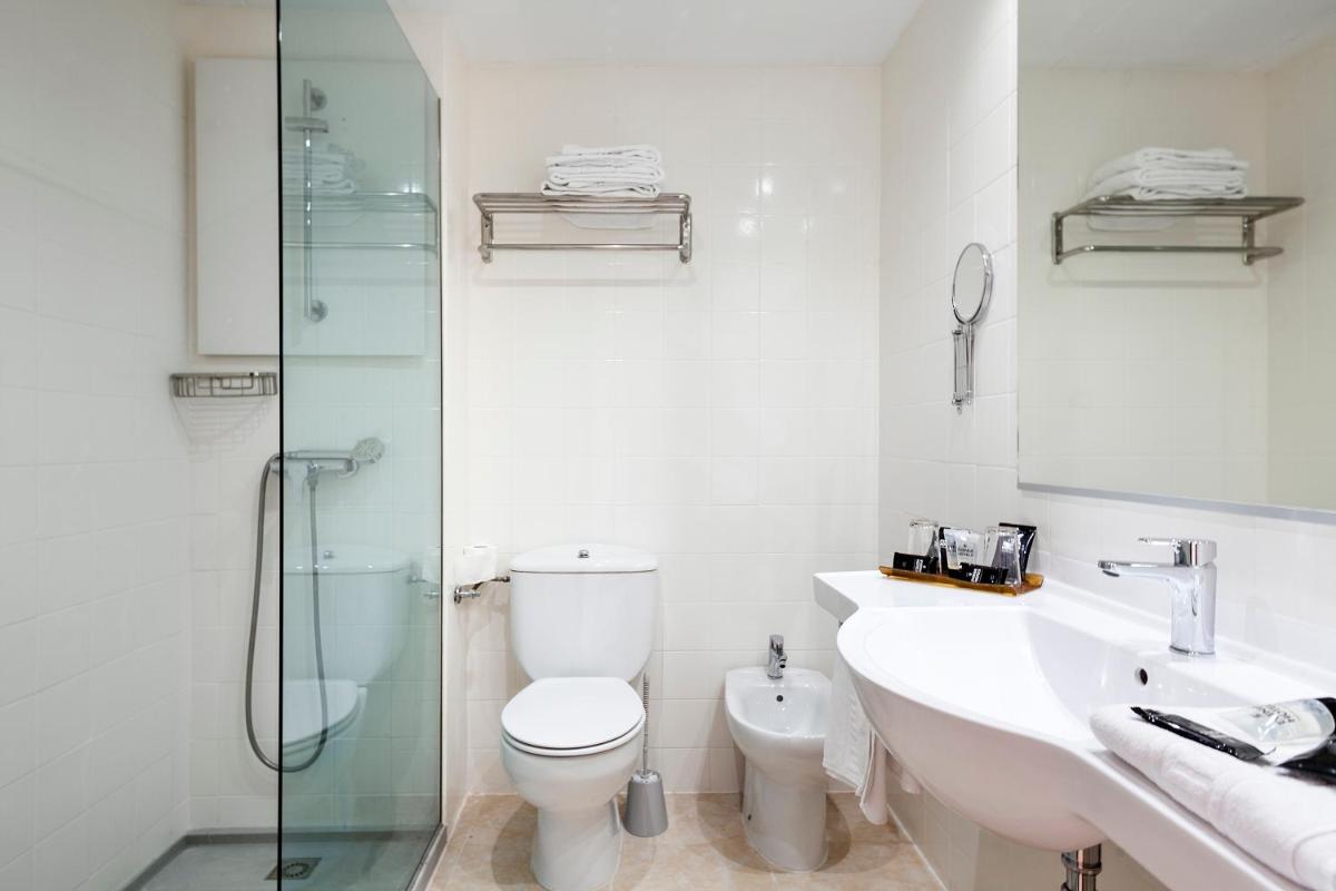 Un baño con inodoro, lavabo y ducha. en Evenia Olympic Resort, en Lloret de Mar