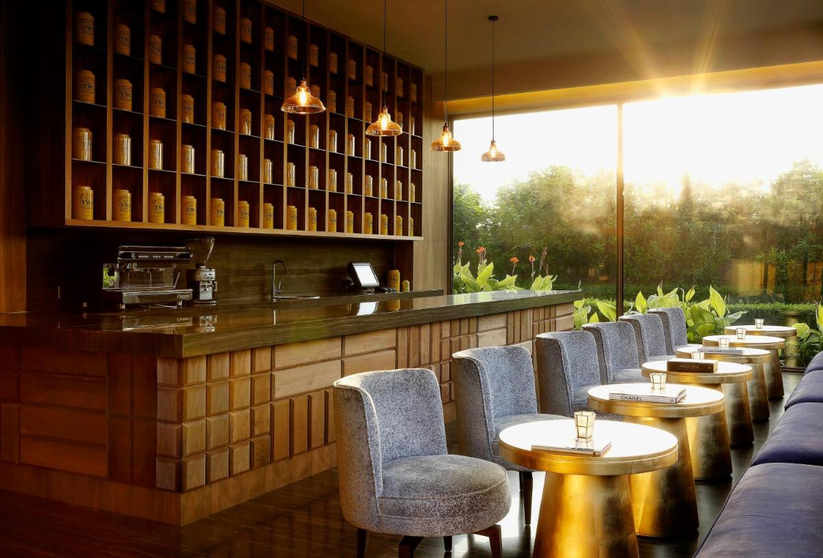 a bar with chairs and tables in a restaurant at Roseate House New Delhi in New Delhi a bar with chairs and tables in a restaurant at Roseate House New Delhi in New Delhi