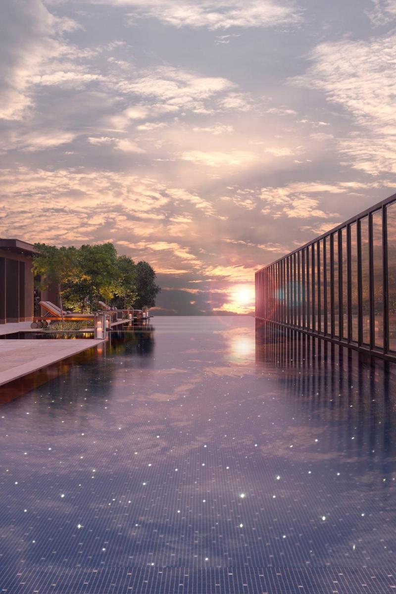 a large body of water with the sun setting on the horizon at Roseate House New Delhi in New Delhi a large body of water with the sun setting on the horizon at Roseate House New Delhi in New Delhi