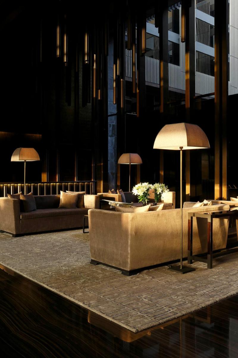 a living room with couches and tables and lamps at Roseate House New Delhi in New Delhi a living room with couches and tables and lamps at Roseate House New Delhi in New Delhi