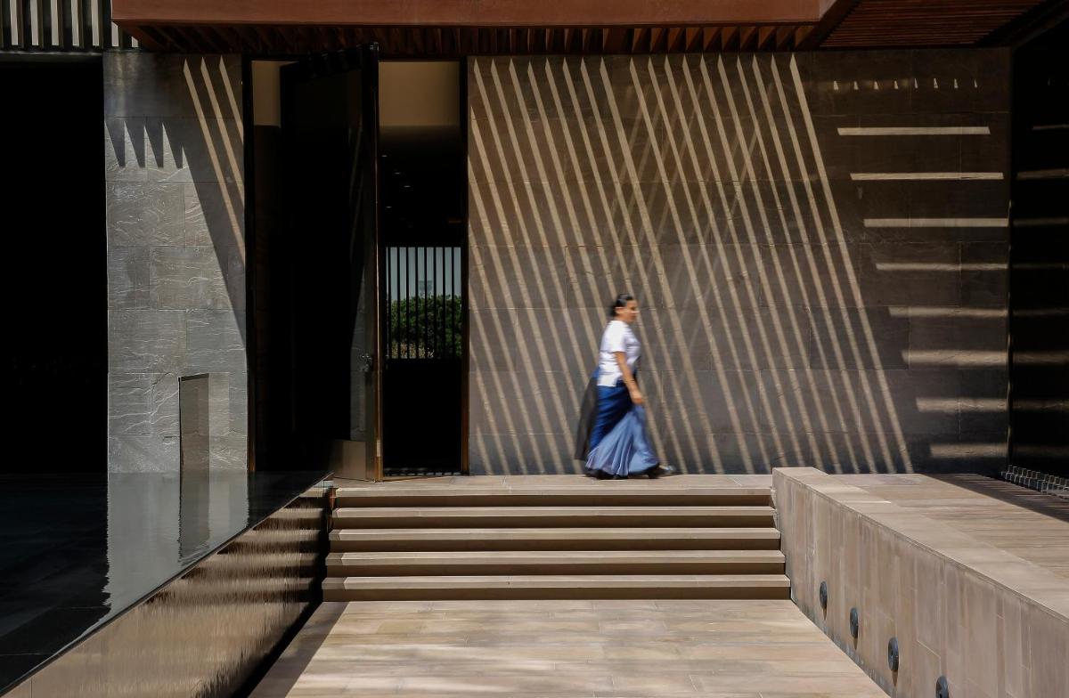 a woman walking up the stairs of a building at Roseate House New Delhi in New Delhi a woman walking up the stairs of a building at Roseate House New Delhi in New Delhi