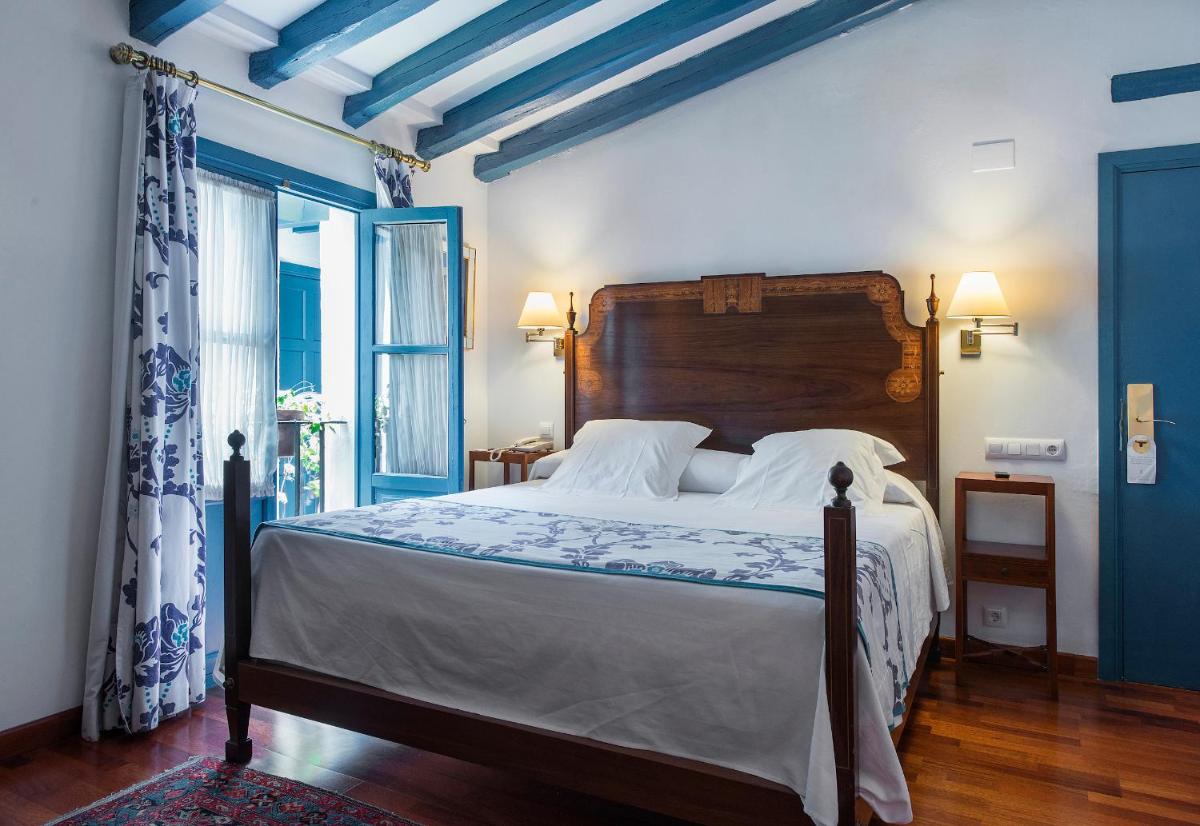 Un dormitorio con una cama grande y una ventana. en Hotel Las Casas de la Judería, en Sevilla 145 fotos más
