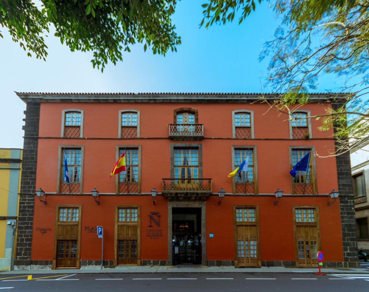 un edificio naranja con banderas delante en Laguna Nivaria Hotel & Spa, en La Laguna