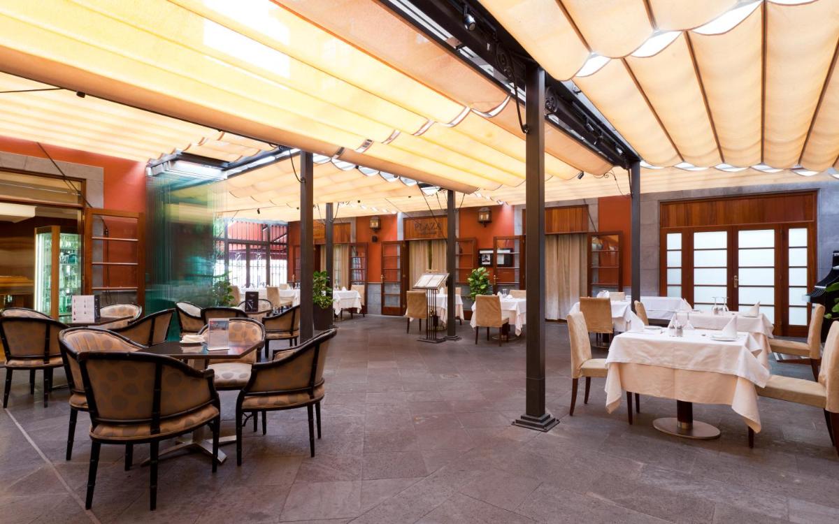 un comedor con mesas, sillas y mesa de comedor en Laguna Nivaria Hotel & Spa, en La Laguna