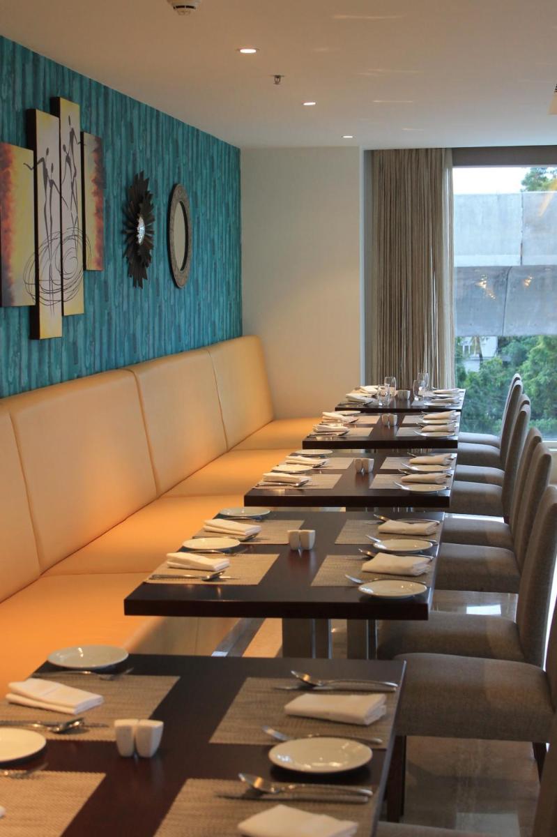 a long dining room with long tables and chairs at Mercure Hyderabad KCP Banjara Hills, An Accor Hotel in Hyderabad