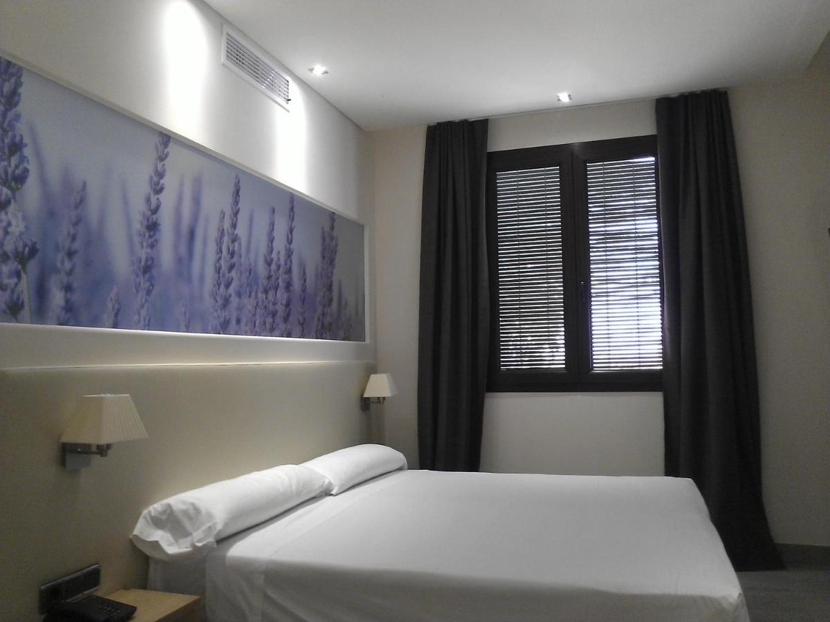 Un dormitorio con una cama blanca y una ventana. en Hotel Balneario El Raposo, en Puebla de Sancho Pérez