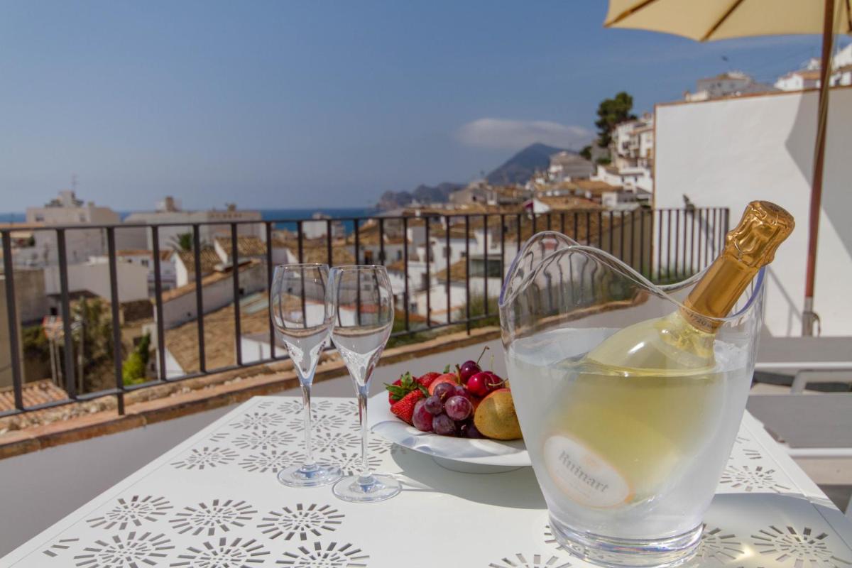 una mesa con dos copas de vino y un plato de comida en La Serena Boutique Hotel & Wellness - Altea, en Altea