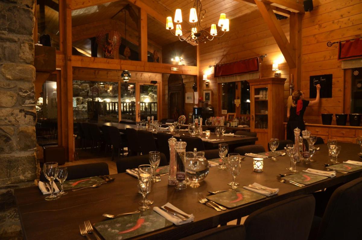 une salle à manger avec une longue table dans un restaurant dans l'établissement Hôtel et Chalet Au Coin Du Feu Chilly Powder, à Morzine