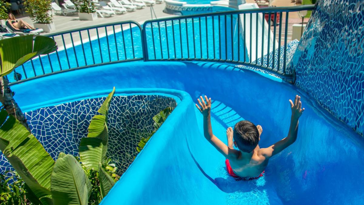 Un niño pequeño en un tobogán en un parque acuático en Hotel RH Vinaros Playa & Spa 4* Sup, en Vinarós