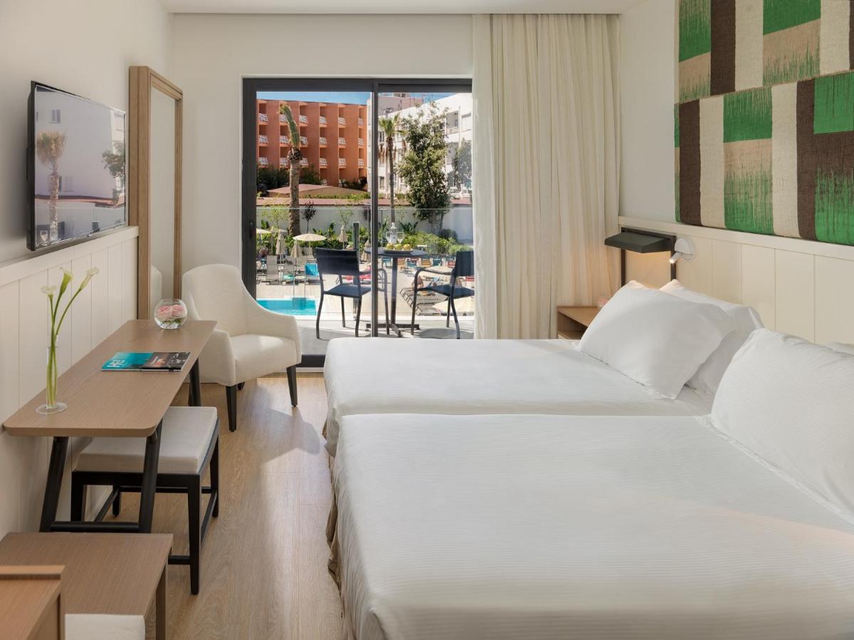 una habitación de hotel con una cama y una mesa en H10 Casa del Mar, en Santa Ponsa 118 fotos más