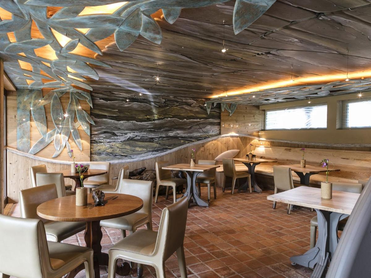un restaurant avec des tables et des chaises et un mur de pierre dans l'établissement Hotel des Berges, Restaurant Gastronomique & Spa, à Illhaeusern