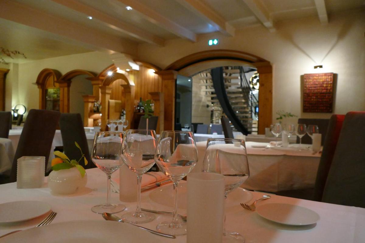 une table avec des verres à vin sur une table dans un restaurant dans l'établissement Logis Hotel Restaurant Le France, à Villers-le-Lac 10 autres photos