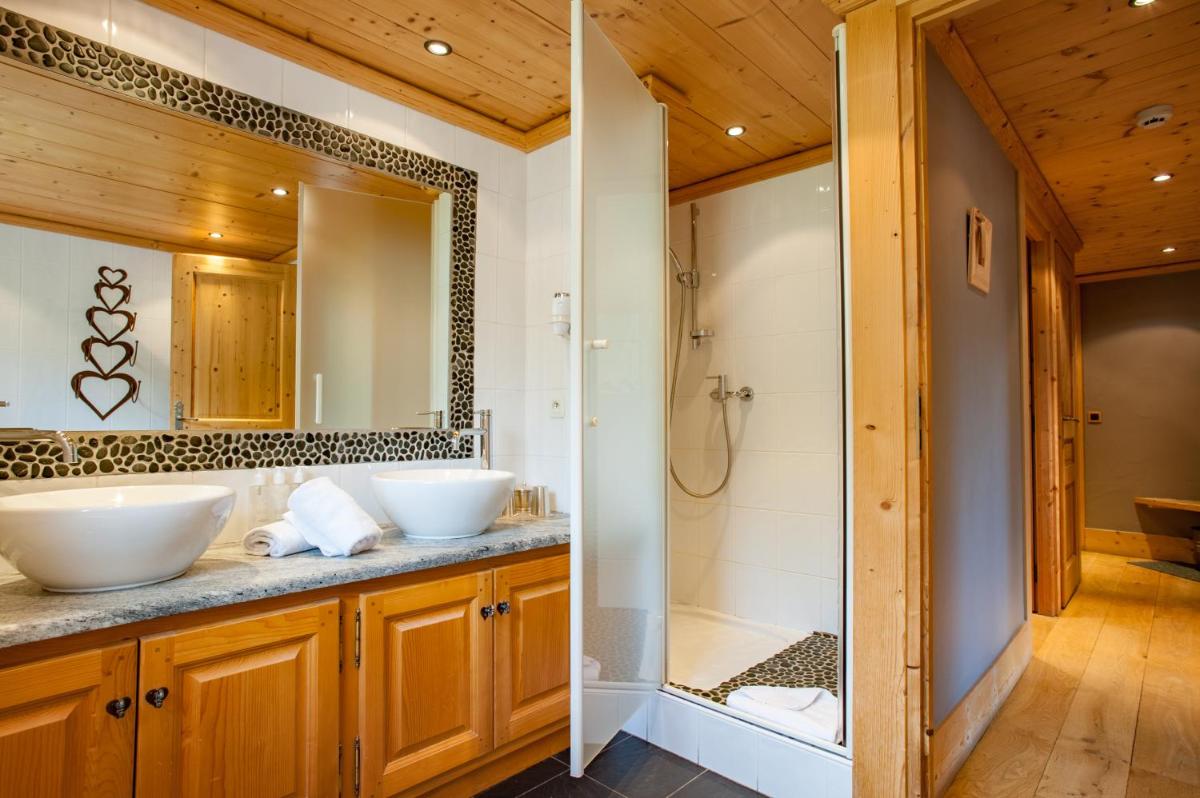 une salle de bain avec deux lavabos et une douche dans l'établissement Chalet-Hôtel Hermitage, à Chamonix-Mont-Blanc 81 autres photos