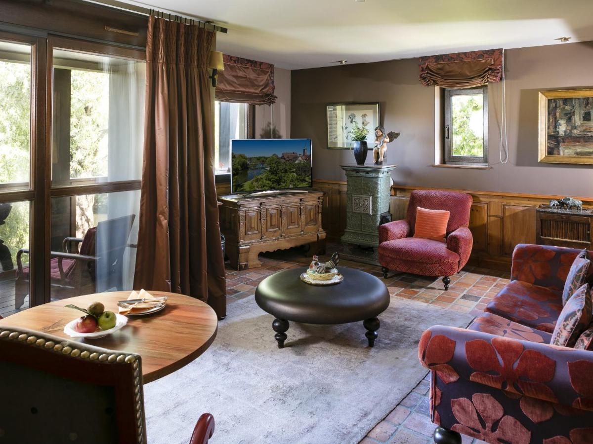 un salon avec un canapé et une télévision dans l'établissement Hotel des Berges, Restaurant Gastronomique & Spa, à Illhaeusern