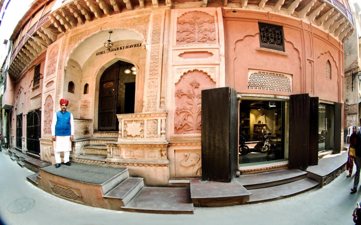 a woman standing in front of a building at Haveli Dharampura & Golden Haveli- UNESCO awarded Boutique Heritage Hotel in New Delhi a woman standing in front of a building at Haveli Dharampura & Golden Haveli- UNESCO awarded Boutique Heritage Hotel in New Delhi