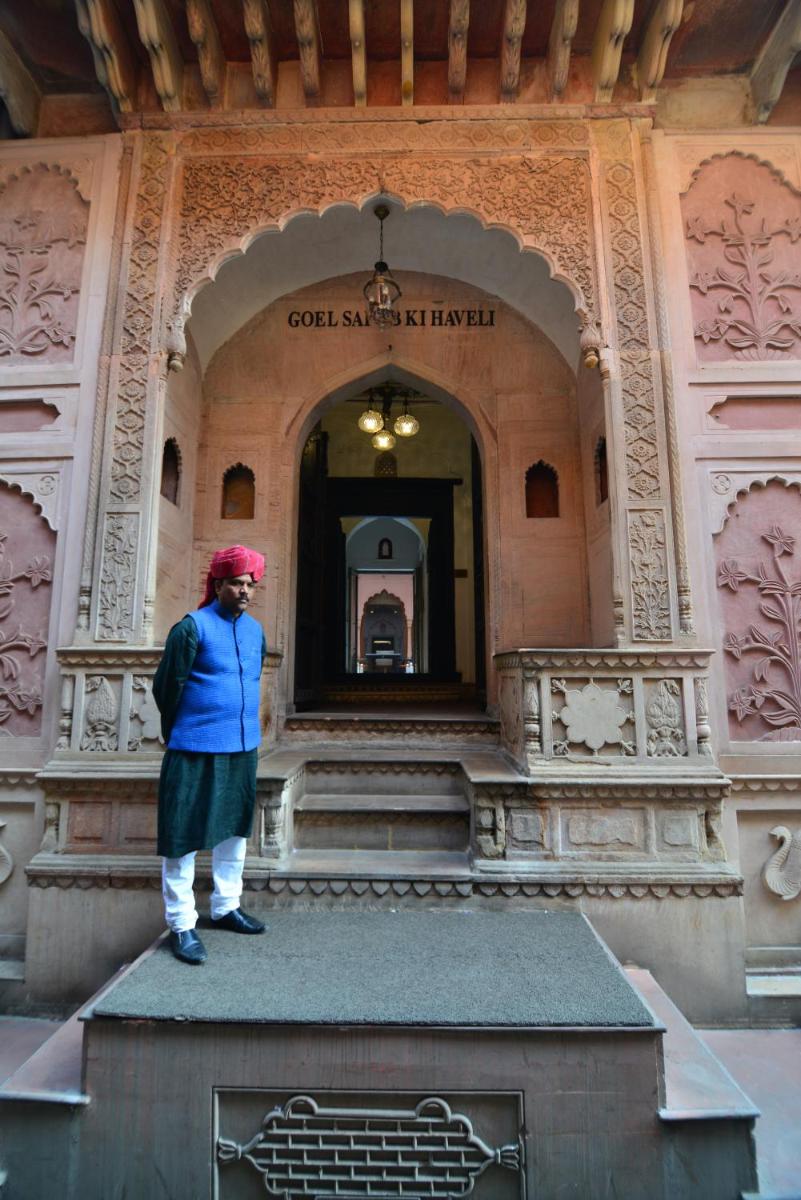 a woman standing in front of a building at Haveli Dharampura & Golden Haveli- UNESCO awarded Boutique Heritage Hotel in New Delhi a woman standing in front of a building at Haveli Dharampura & Golden Haveli- UNESCO awarded Boutique Heritage Hotel in New Delhi