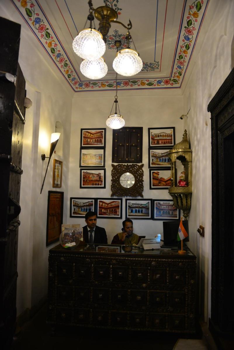 two men sitting at a desk in a room at Haveli Dharampura & Golden Haveli- UNESCO awarded Boutique Heritage Hotel in New Delhi two men sitting at a desk in a room at Haveli Dharampura & Golden Haveli- UNESCO awarded Boutique Heritage Hotel in New Delhi