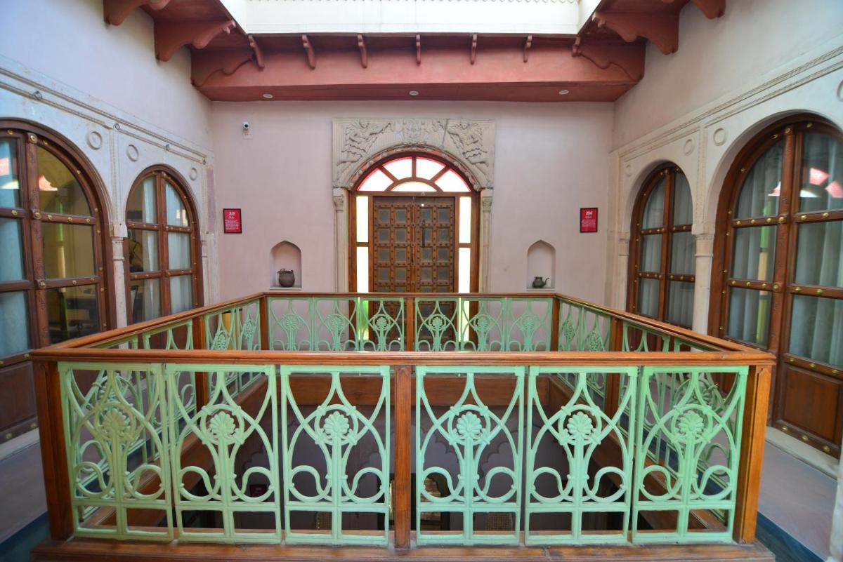 an ornate balcony in a building with a window at Haveli Dharampura & Golden Haveli- UNESCO awarded Boutique Heritage Hotel in New Delhi an ornate balcony in a building with a window at Haveli Dharampura & Golden Haveli- UNESCO awarded Boutique Heritage Hotel in New Delhi