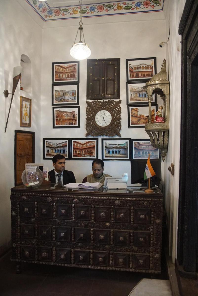 two men sitting at a desk in a room at Haveli Dharampura & Golden Haveli- UNESCO awarded Boutique Heritage Hotel in New Delhi two men sitting at a desk in a room at Haveli Dharampura & Golden Haveli- UNESCO awarded Boutique Heritage Hotel in New Delhi