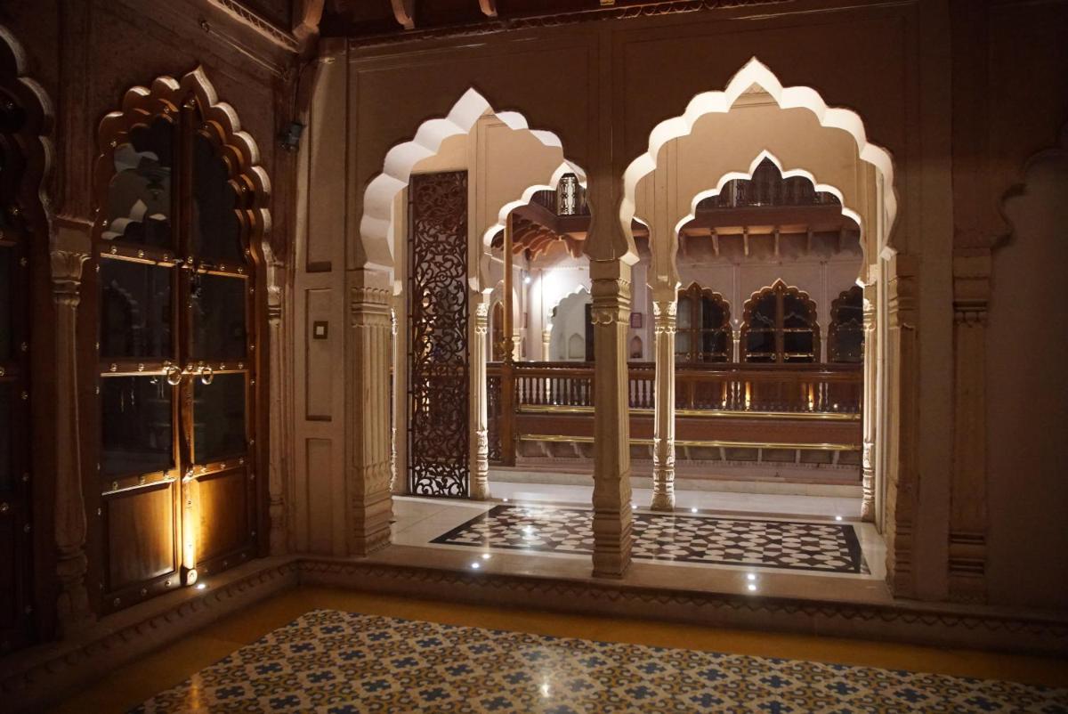 a room with two entrances to a building with ornate doors at Haveli Dharampura & Golden Haveli- UNESCO awarded Boutique Heritage Hotel in New Delhi a room with two entrances to a building with ornate doors at Haveli Dharampura & Golden Haveli- UNESCO awarded Boutique Heritage Hotel in New Delhi