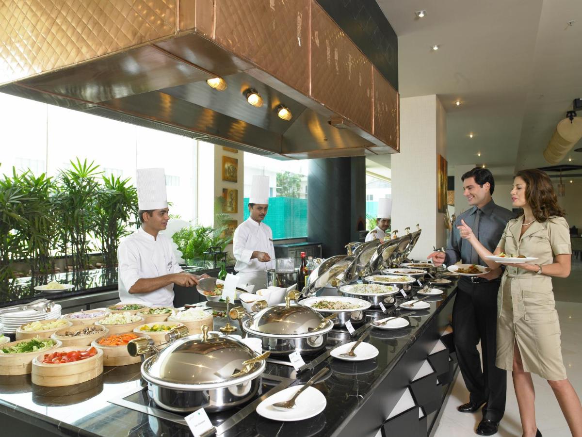 a group of people standing in a kitchen preparing food at The Zuri Whitefield Bengaluru in Bengaluru