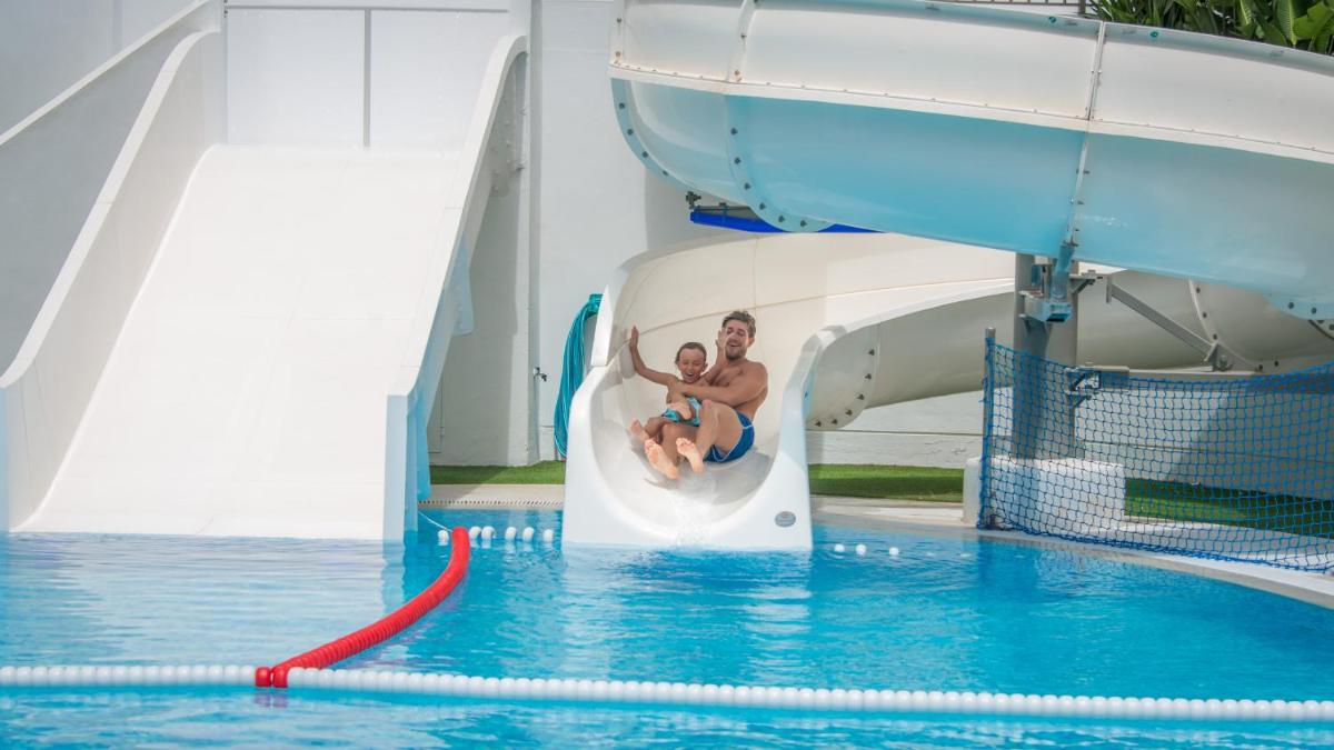 un hombre y un niño en un tobogán de agua en una piscina en RH Princesa Hotel & Spa 4* Sup, en Benidorm