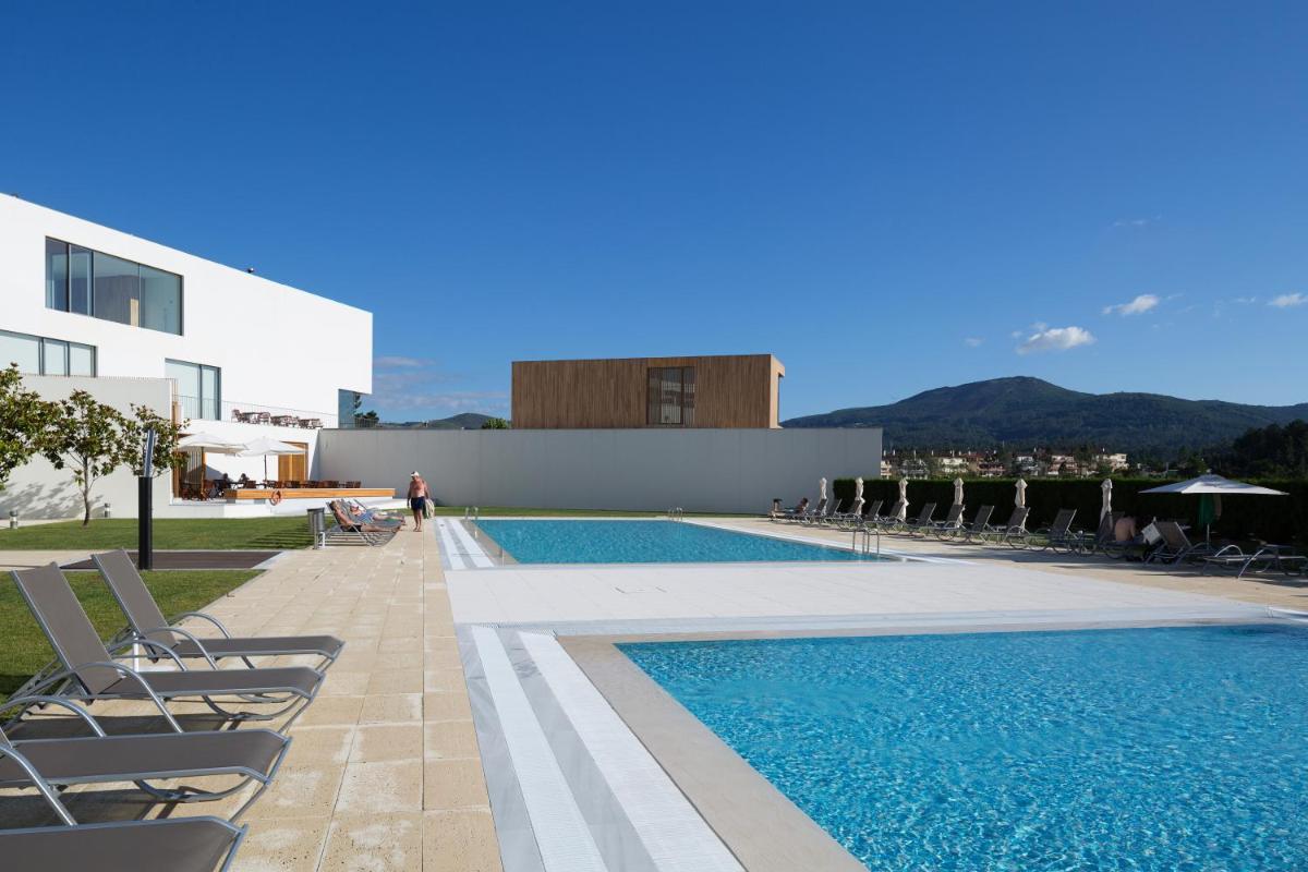 uma piscina com espreguiçadeiras ao lado de um edifício em Hotel Minho em Vila Nova de Cerveira