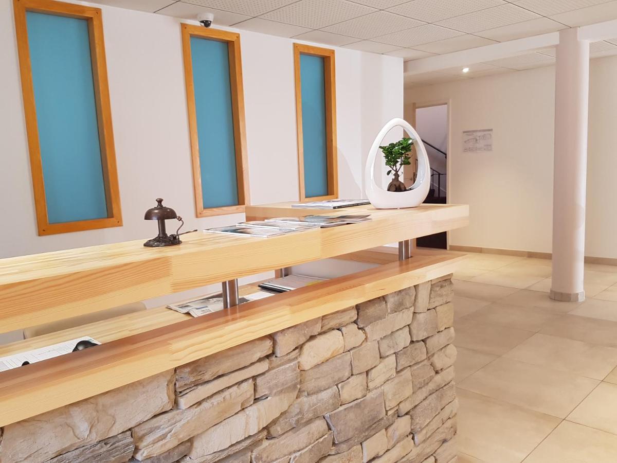 La salle de bains est pourvue d'un comptoir en pierre et d'un miroir. dans l'établissement Hotel Spa Les Rives Sauvages, à Malbuisson