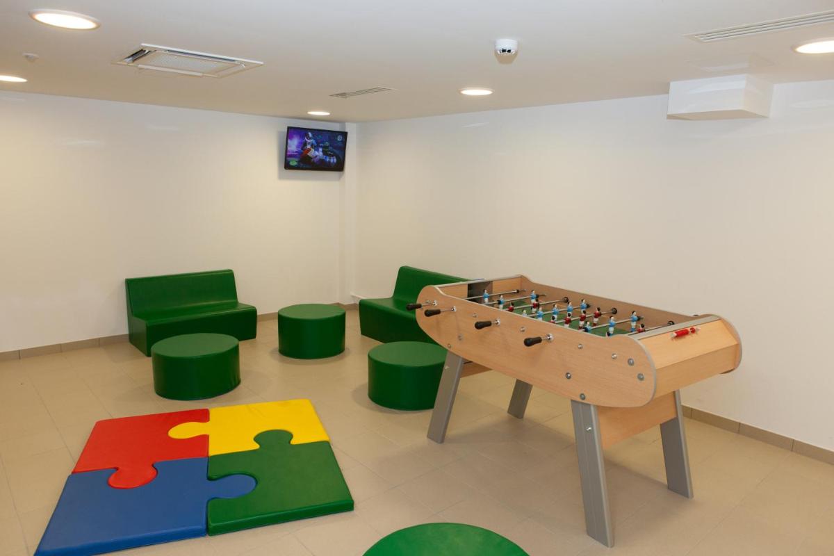 Cette chambre comprend un baby-foot et des chaises vertes. dans l'établissement Hotel Restaurant Le Cleebourg, à Rott