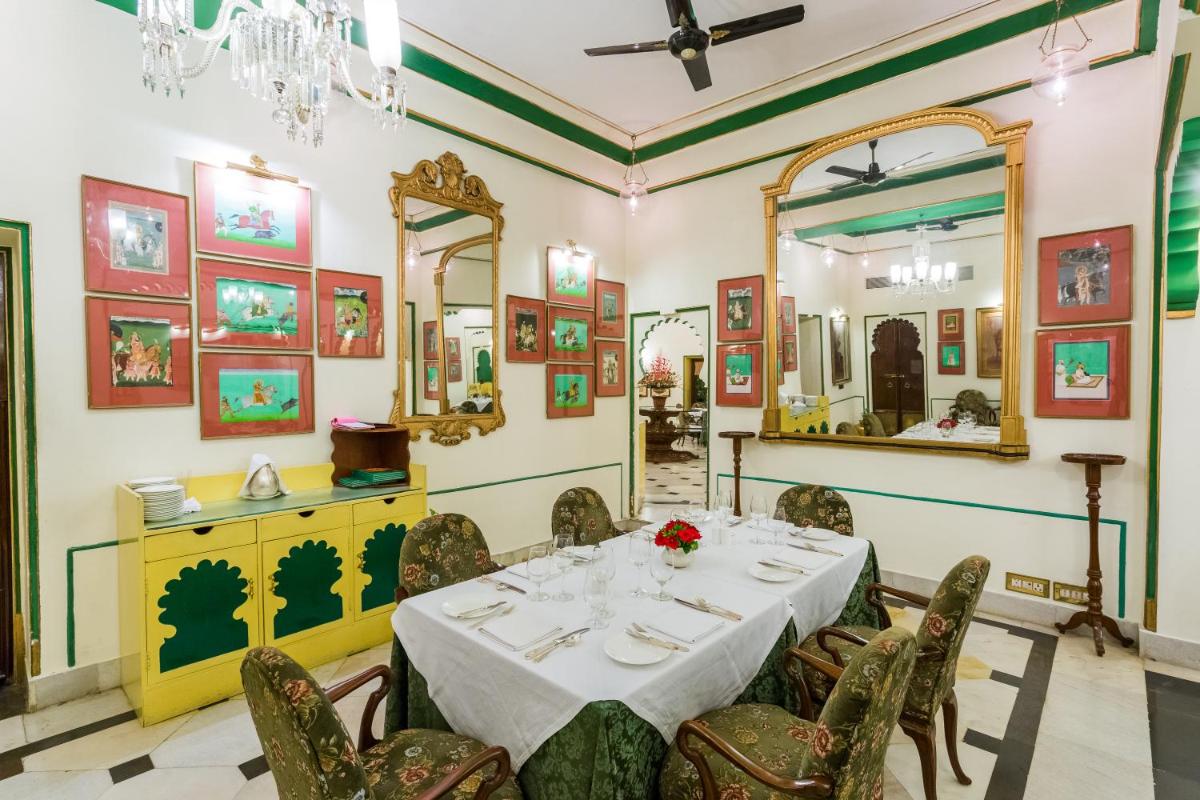 a dining room with a table and chairs and a mirror at Shiv Niwas Palace by HRH Group of Hotels in Udaipur
