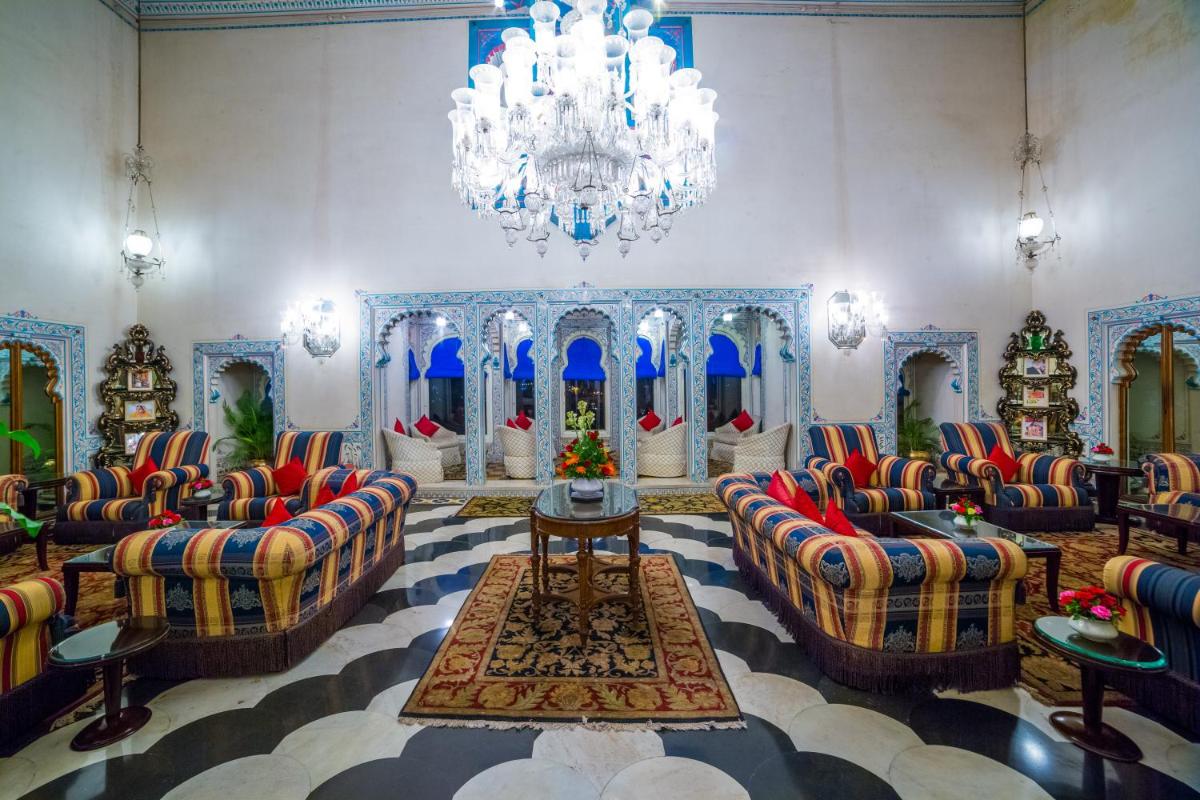 a large room with couches and a chandelier at Shiv Niwas Palace by HRH Group of Hotels in Udaipur