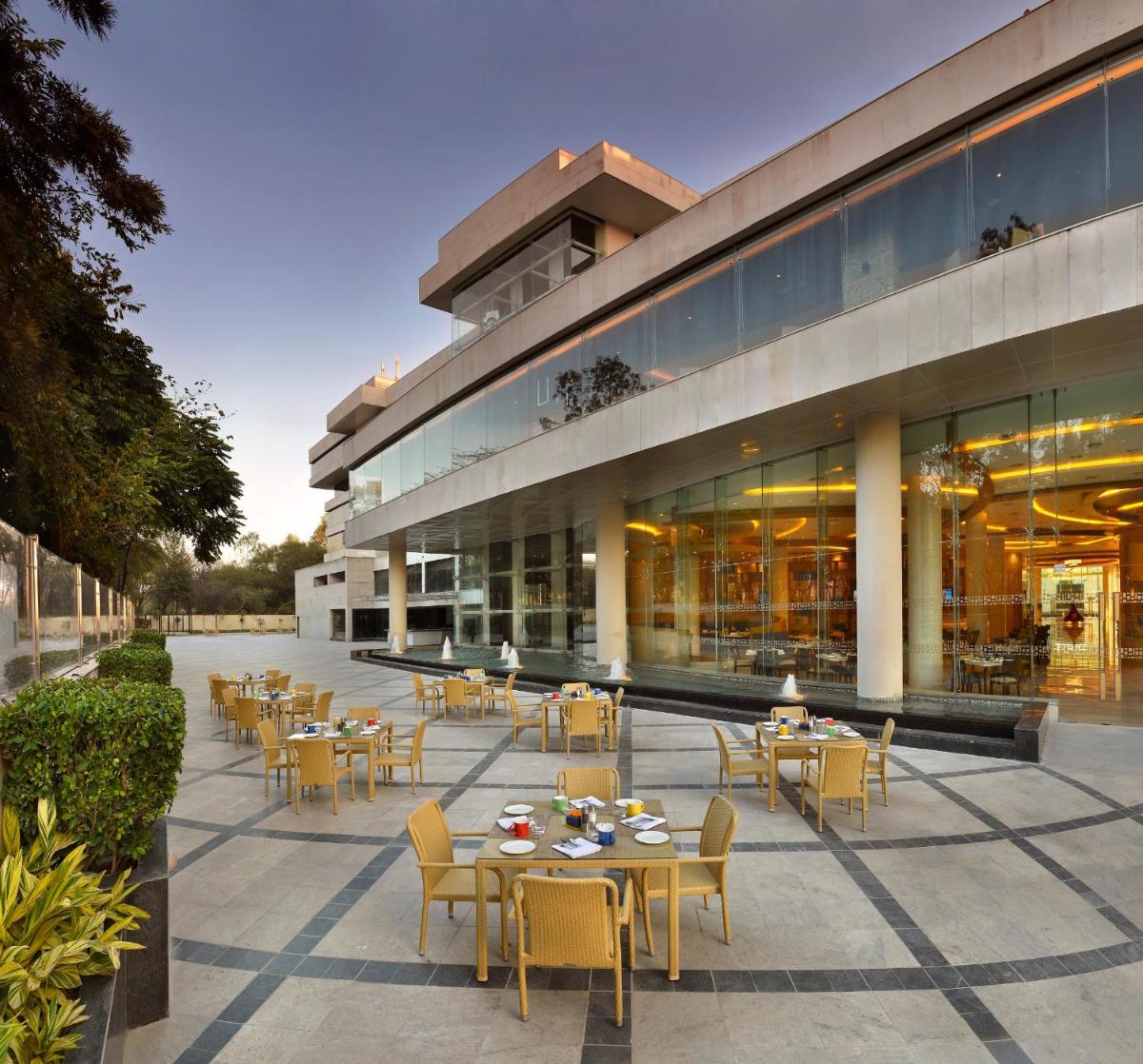 a restaurant with tables and chairs in front of a building at The Lalit Chandigarh in Chandīgarh