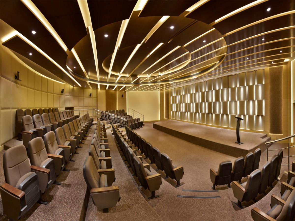 an empty lecture hall with chairs and a stage at The Lalit Chandigarh in Chandīgarh