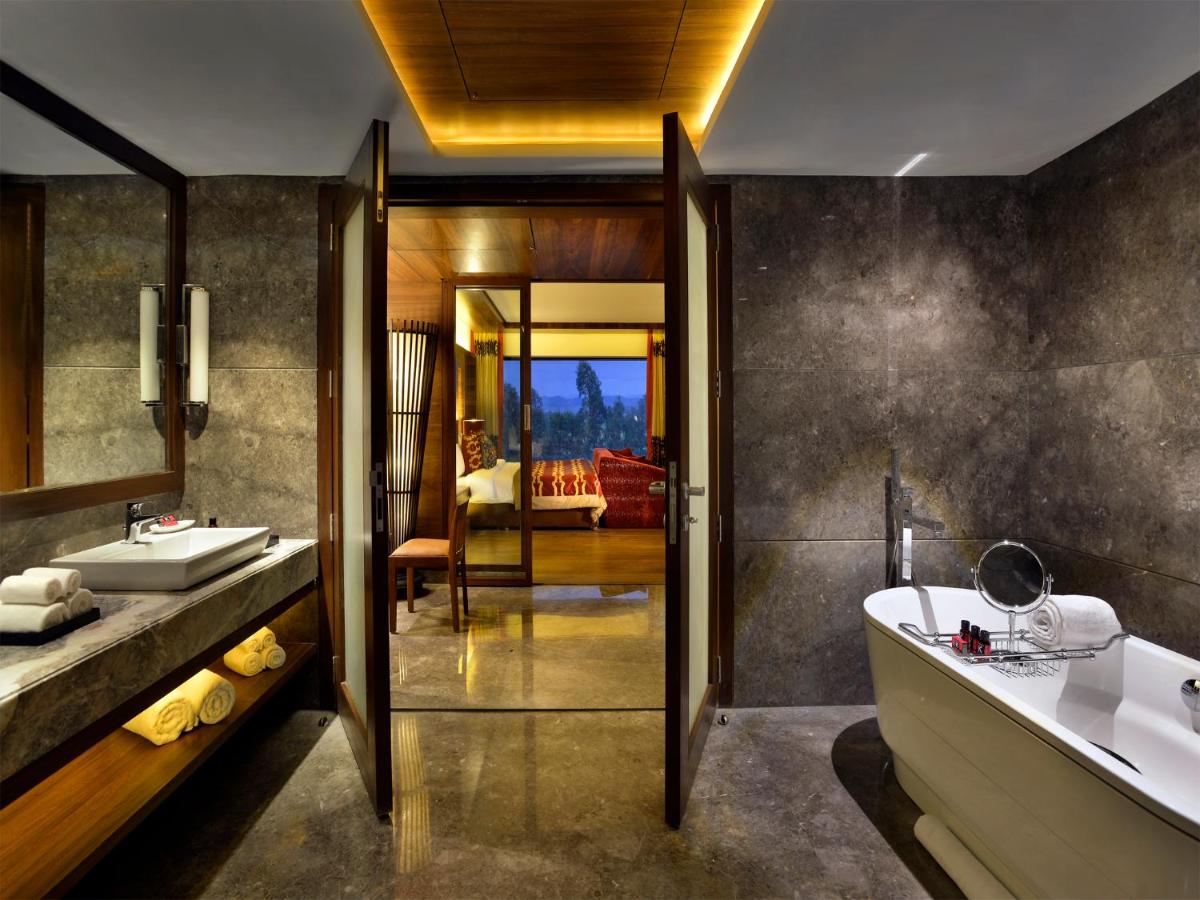 a bathroom with two sinks and a tub and a bath tub at The Lalit Chandigarh in Chandīgarh
