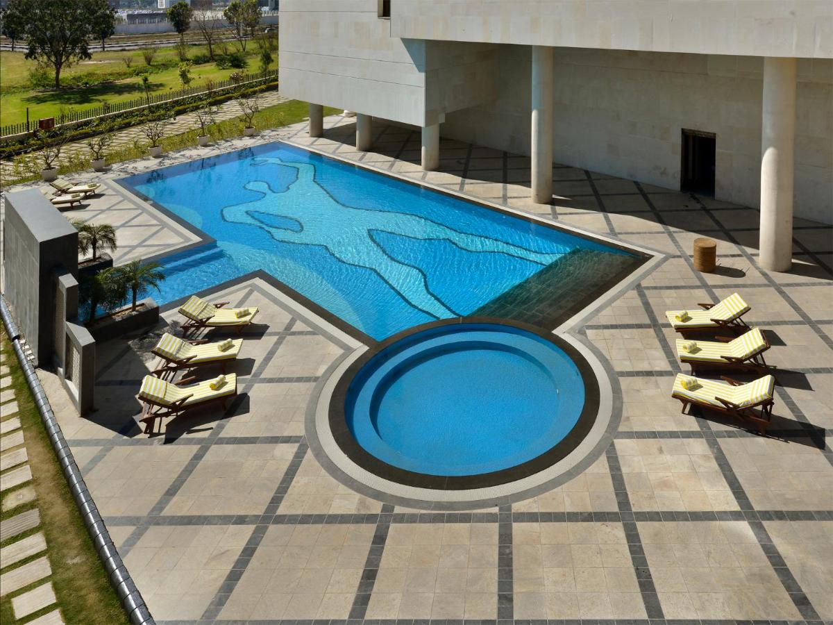 an overhead view of a swimming pool in a building at The Lalit Chandigarh in Chandīgarh