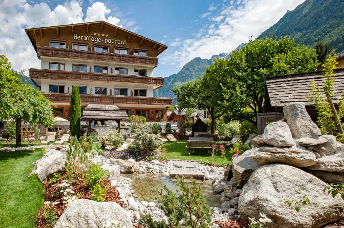 un hôtel avec un jardin en face d'un bâtiment dans l'établissement Chalet-Hôtel Hermitage, à Chamonix-Mont-Blanc