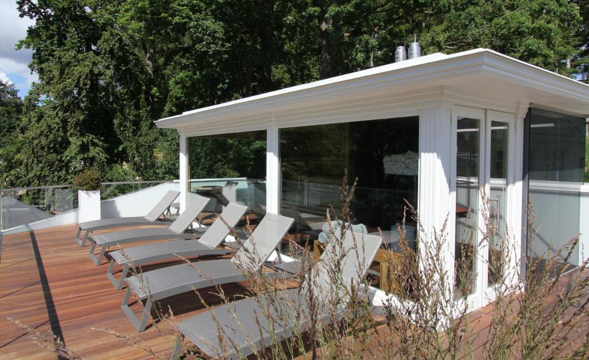 eine Gruppe weißer Stühle auf einer Terrasse in der Unterkunft ROEWERS Privathotel & Spa in Ostseebad Sellin